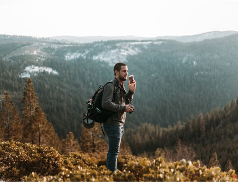 A man on a cellphone in the mountains